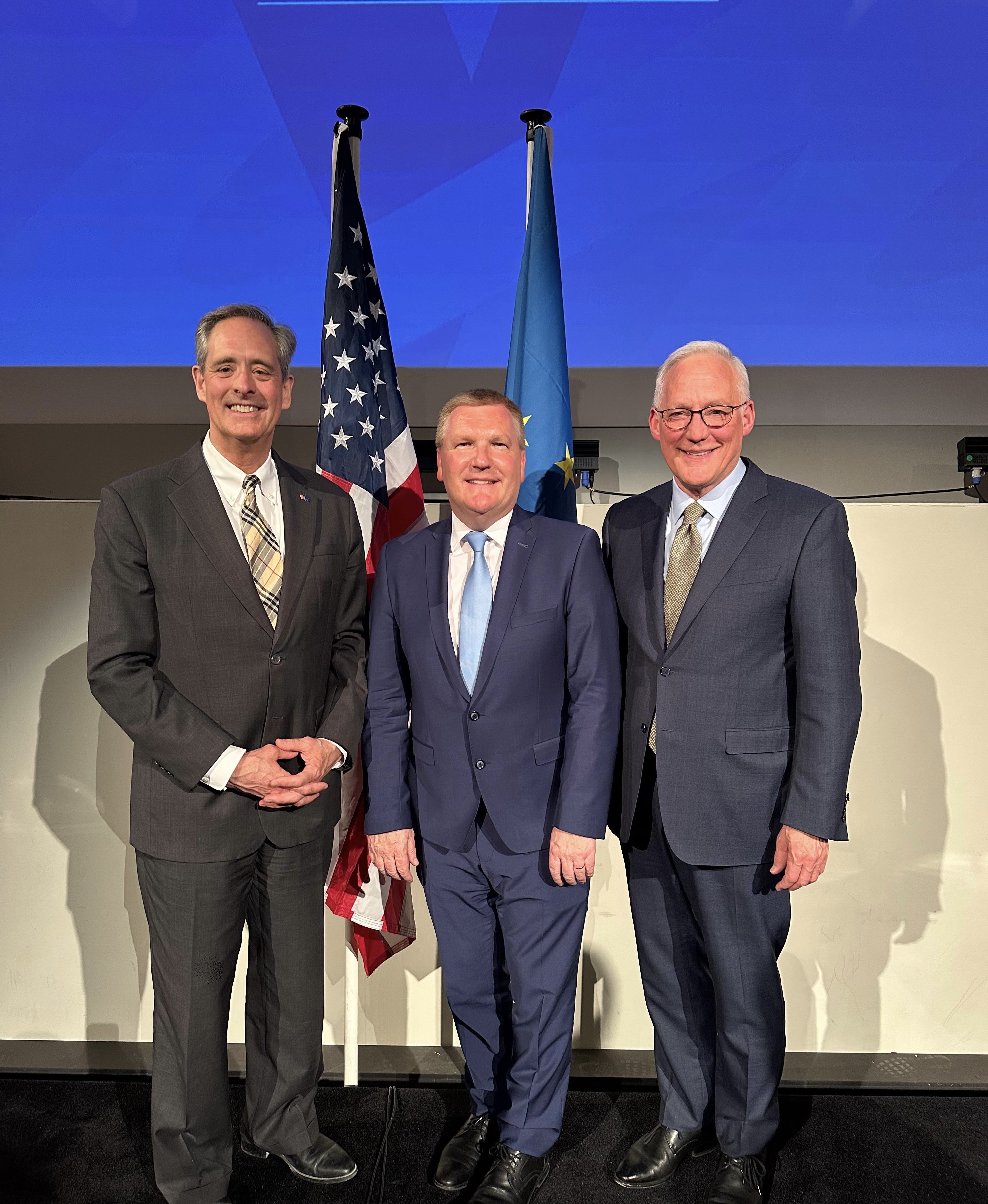 Ambassador McGrath with Minister Michael McGrath and a colleague before the U.S. and EU flags